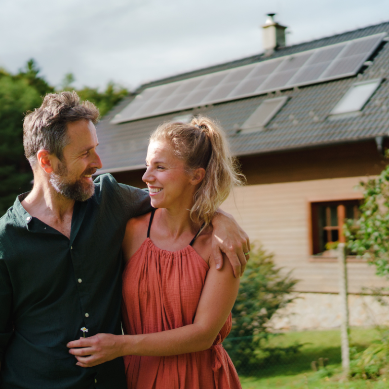 a couple in front of their solar home