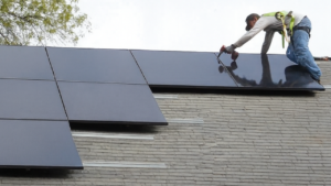 someone installing solar panels on a roof